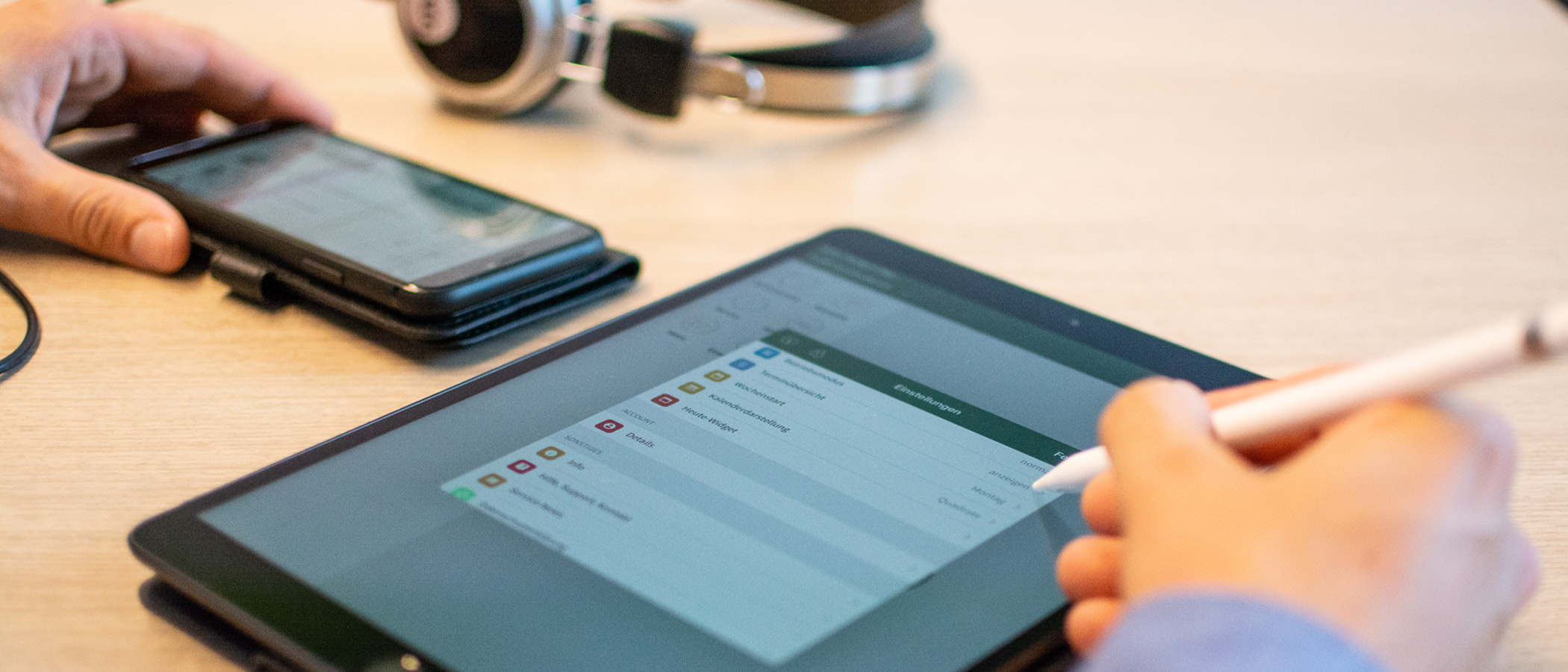 eine Person bedient ein Tablet auf einem Schreibtisch - zur Übersichtsseite Digitales